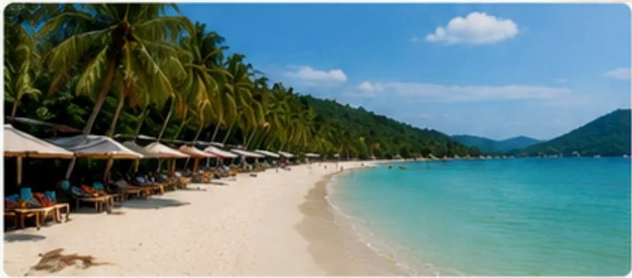 Long curving beach with sun loungers, parasols and palm trees beside calm water