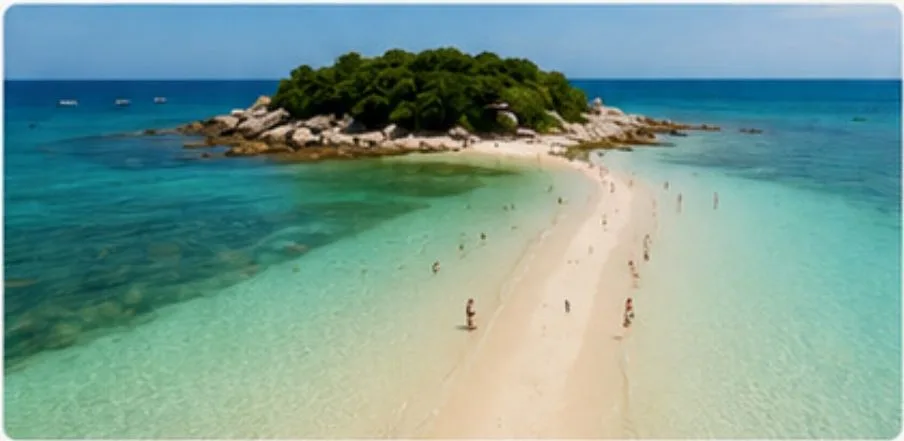 Natural sandbar reaching out through shallow turquoise water to a small green island